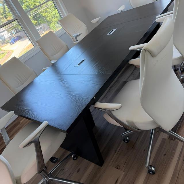 Office conference table with white office chairs, assembled