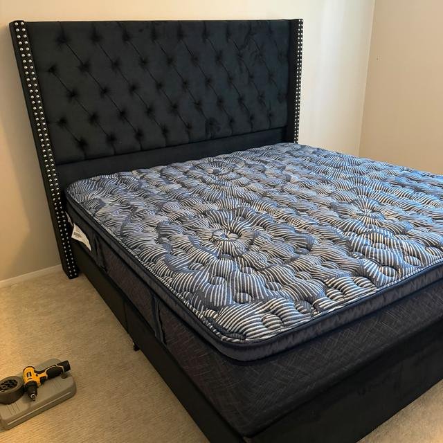 Tufted upholstered king bed frame, assembled with the mattress in place